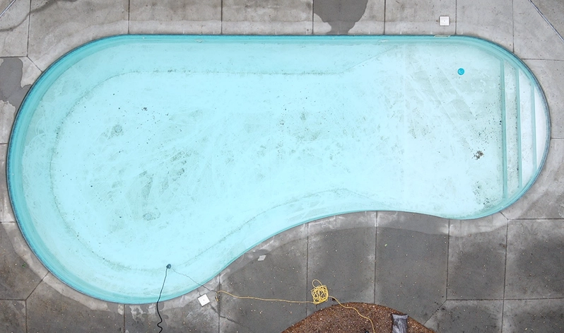 Aerial perspective of a pool reflecting the blue sky, showcasing the serene water and surrounding area.