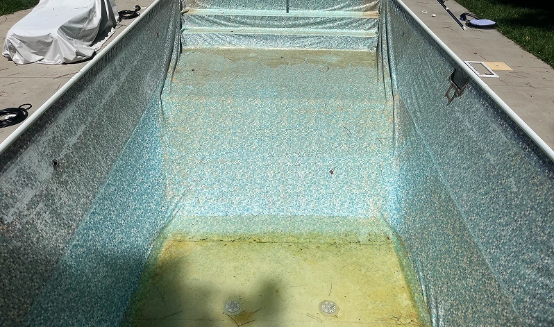 A swimming pool covered with a blue tarp, indicating it is not in use at the moment.