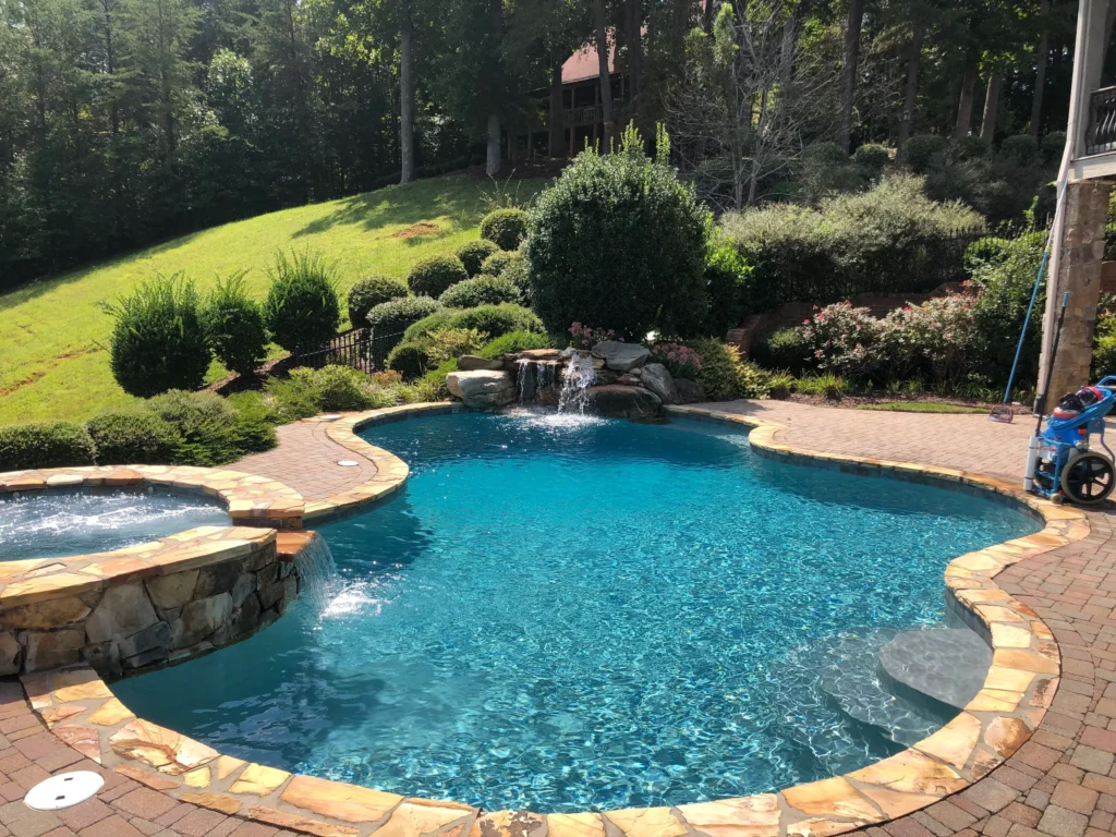 Luxury backyard pool with stone edging and waterfall feature