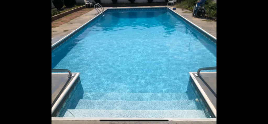 Clean rectangular swimming pool with clear blue water after treatment