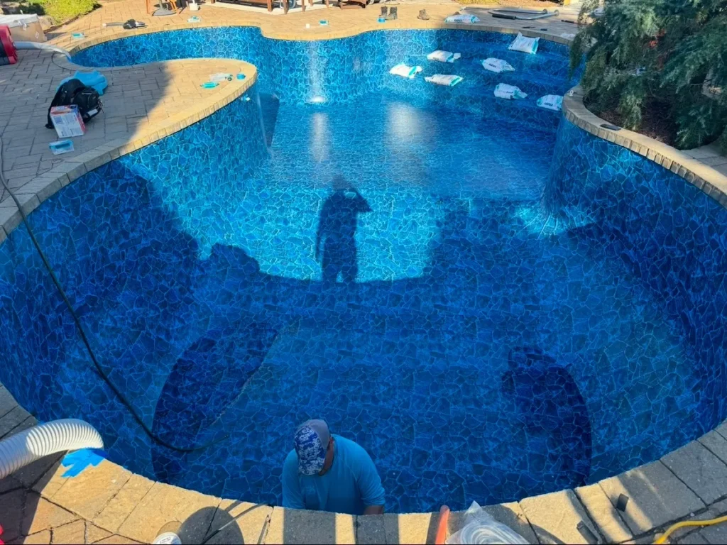 Empty swimming pool under renovation with new blue mosaic liner installation