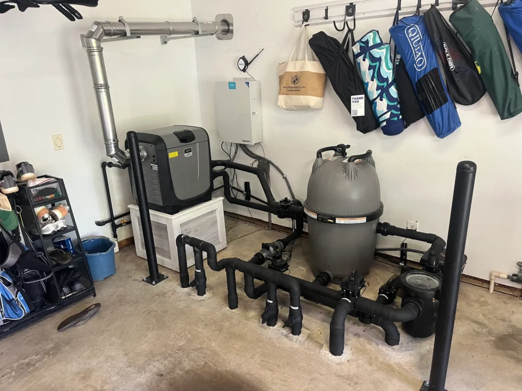 Upgraded indoor pool equipment system with new heater, filter, and black piping installation