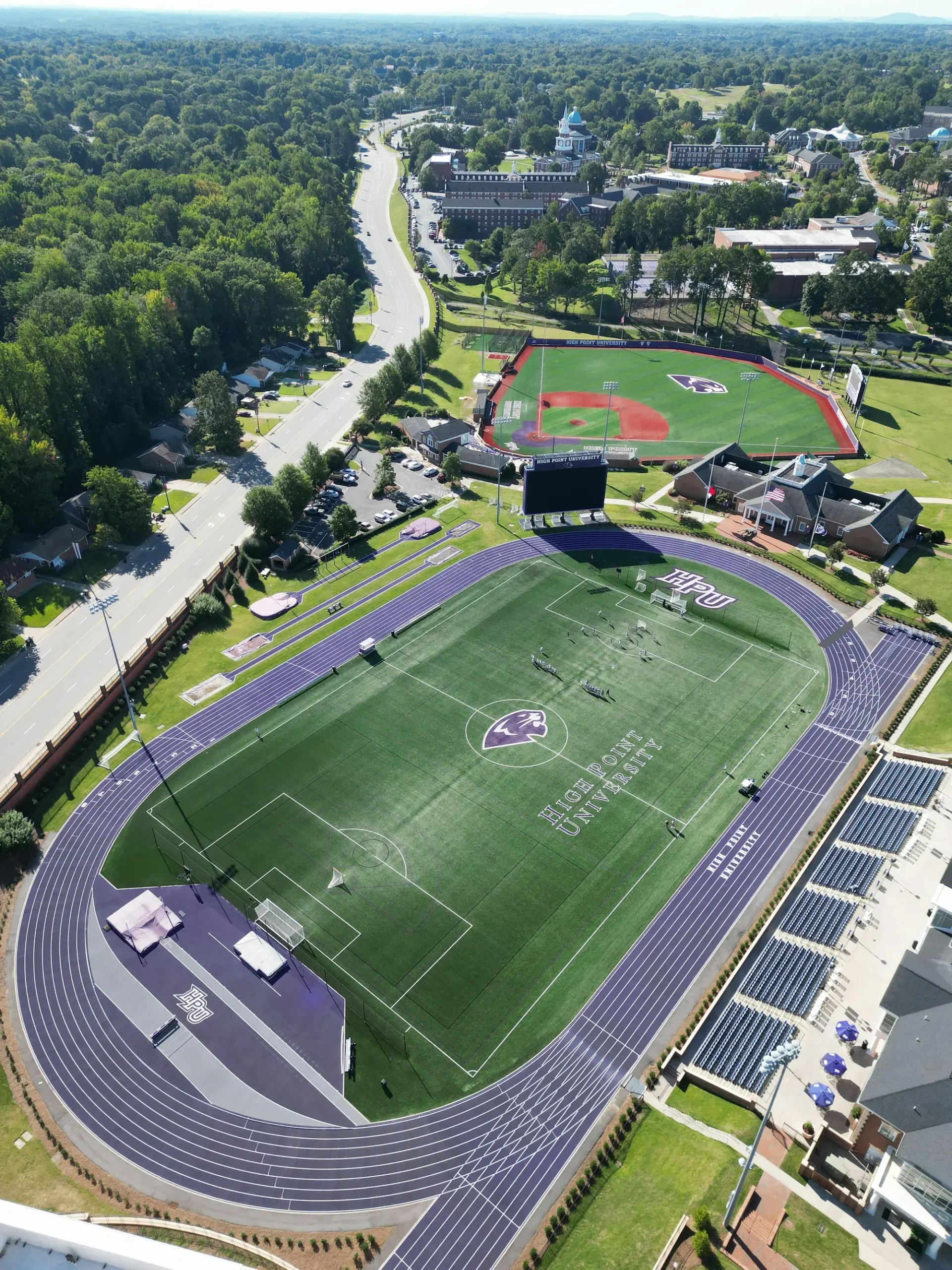Aerial view of a soccer field surrounded by a stadium, showcasing the green pitch and seating areas.